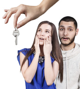 Dealer handing keys to happy young couple